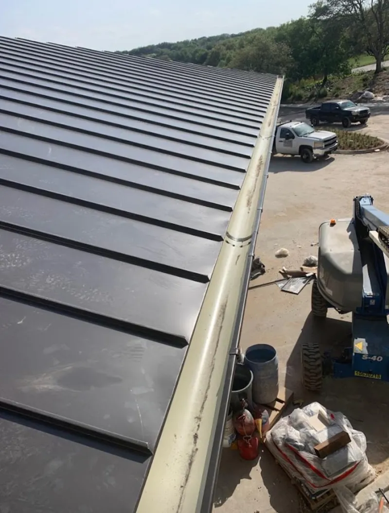 Standing seam panel and gutter detail on a metal roofing jobsite in Lake Jackson